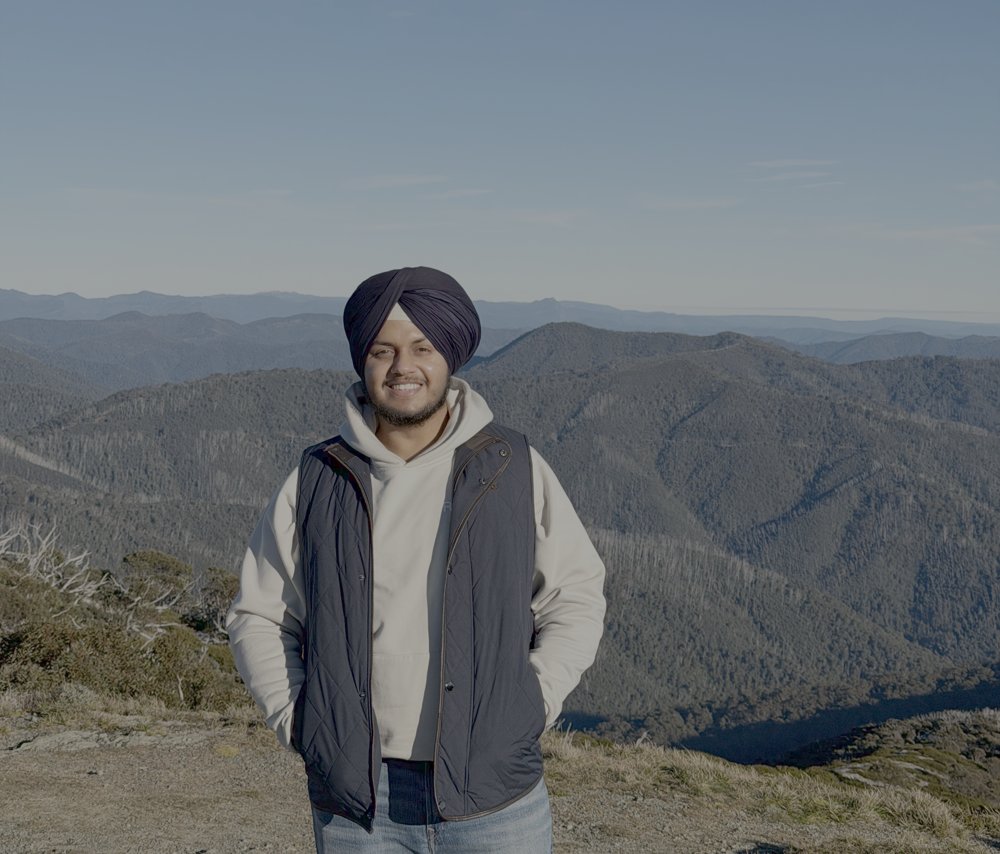 Gurwinder Singh, standing on a mountain summit